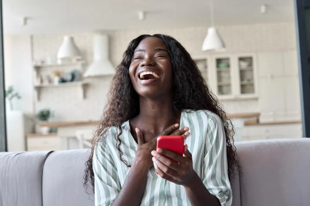Excited Young Black Woman Holding Phone Feeling Joy