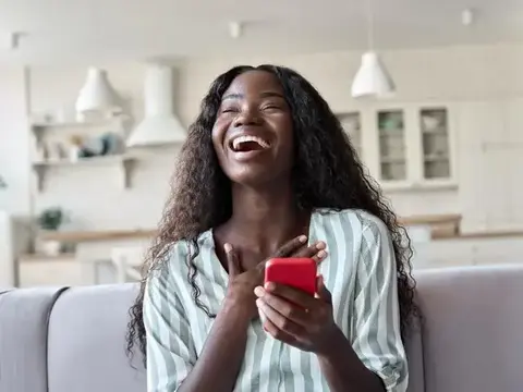 Customer smiling while holding her Samsung phone