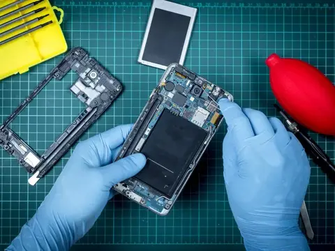 Technician repairing components inside a smartphone